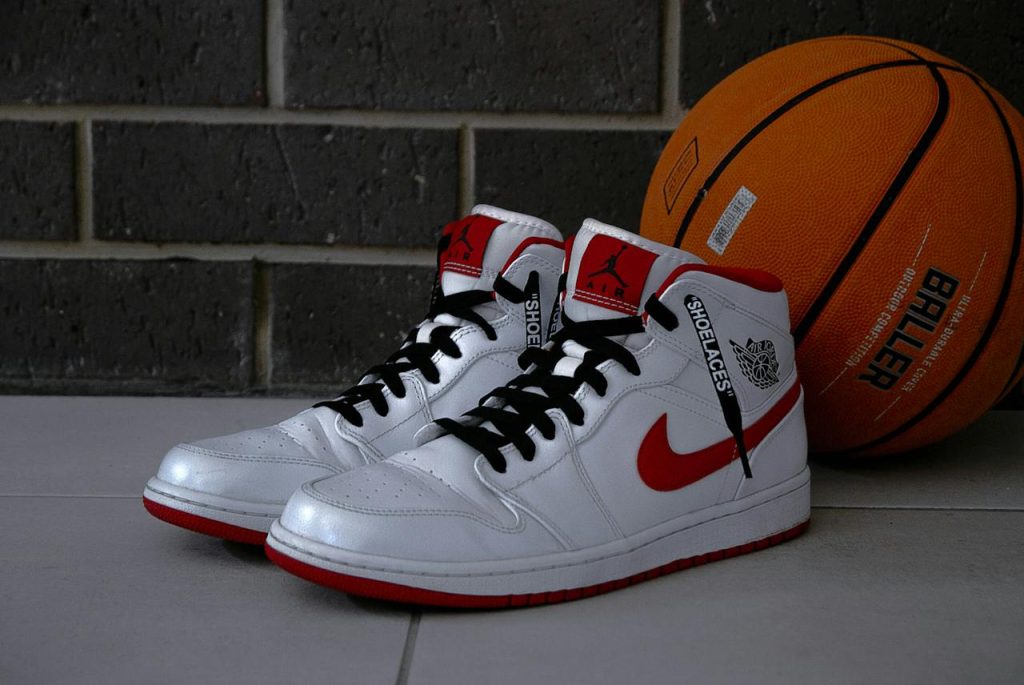 a pair of white sneakers next to a basketball